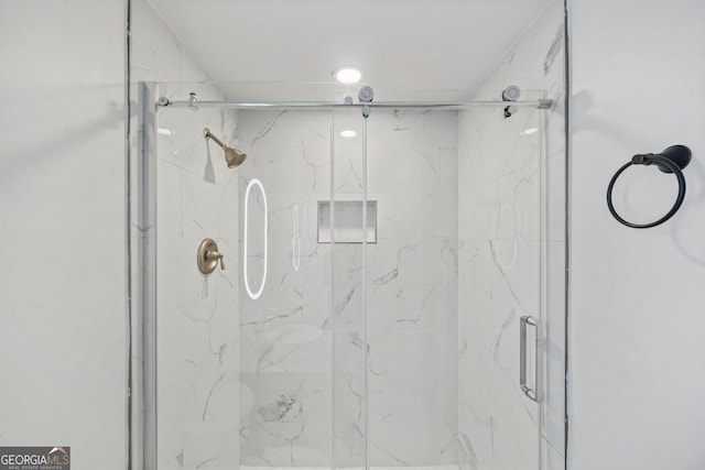 bathroom with a shower with door