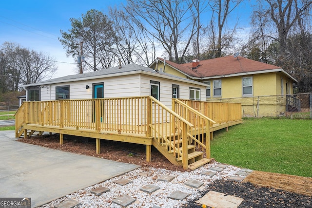 rear view of house featuring a yard and a deck