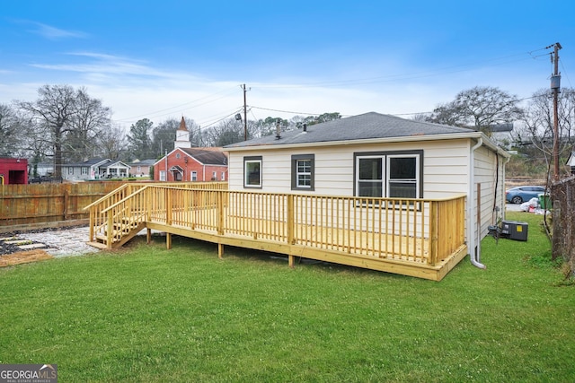 back of house with a deck and a lawn