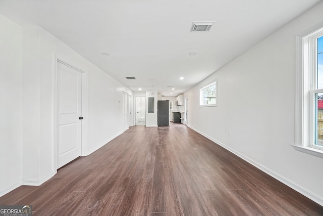 unfurnished living room with a wealth of natural light and dark hardwood / wood-style floors