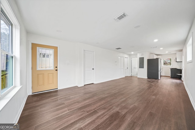 unfurnished living room with dark hardwood / wood-style flooring and electric panel