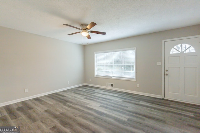 foyer featuring dark hardwood / wood-style flooring, a textured ceiling, ceiling fan, and a wealth of natural light