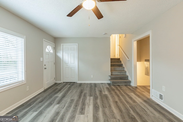 foyer entrance with ceiling fan, dark hardwood / wood-style floors, and a textured ceiling