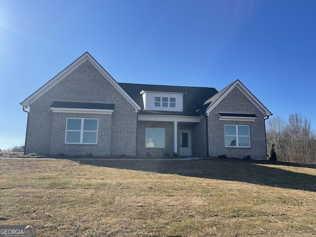 view of front facade featuring brick siding and a front lawn