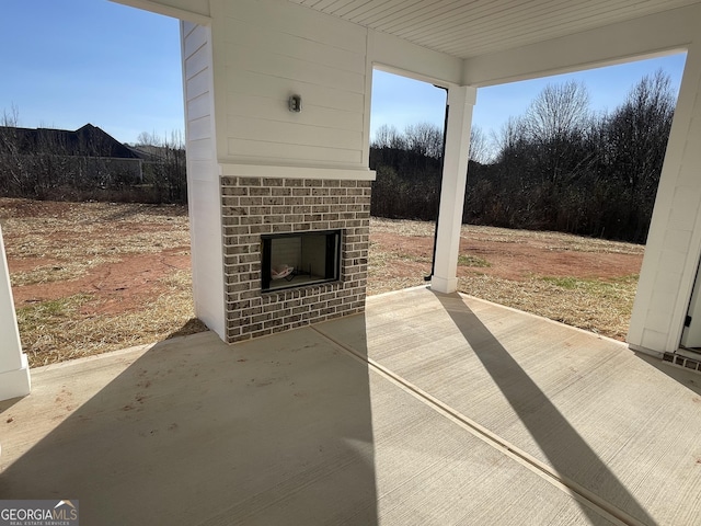 view of patio / terrace featuring an outdoor brick fireplace