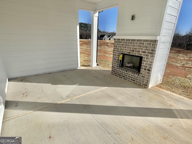 view of patio / terrace featuring an outdoor brick fireplace