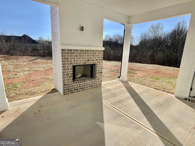 view of patio featuring an outdoor brick fireplace