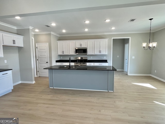 kitchen featuring visible vents, white cabinetry, appliances with stainless steel finishes, dark countertops, and pendant lighting