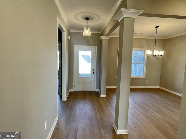 entryway featuring ornamental molding, baseboards, ornate columns, and wood finished floors