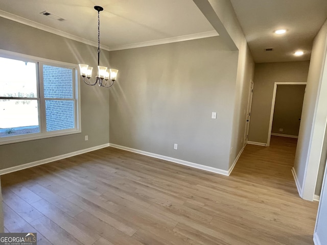 unfurnished room with baseboards, visible vents, ornamental molding, wood finished floors, and a chandelier