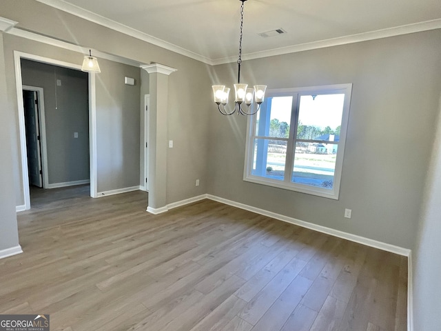 unfurnished dining area featuring light wood-style floors, baseboards, visible vents, and ornamental molding