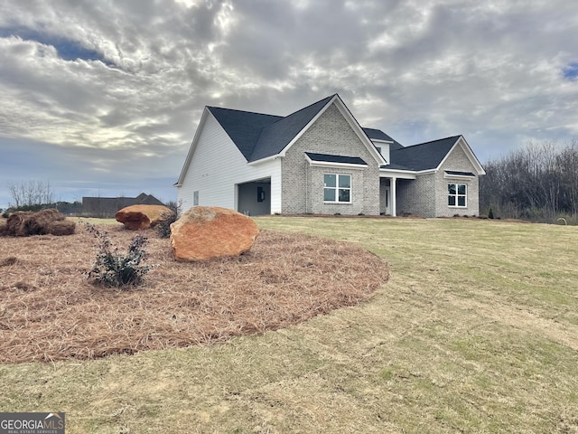 view of front of house featuring a garage, brick siding, and a front yard