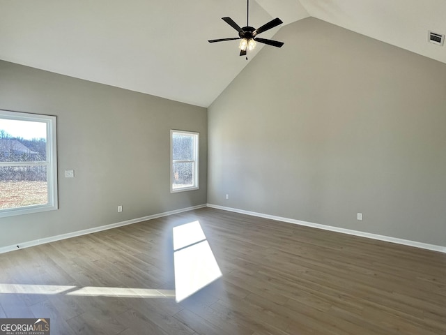 empty room featuring visible vents, ceiling fan, wood finished floors, high vaulted ceiling, and baseboards