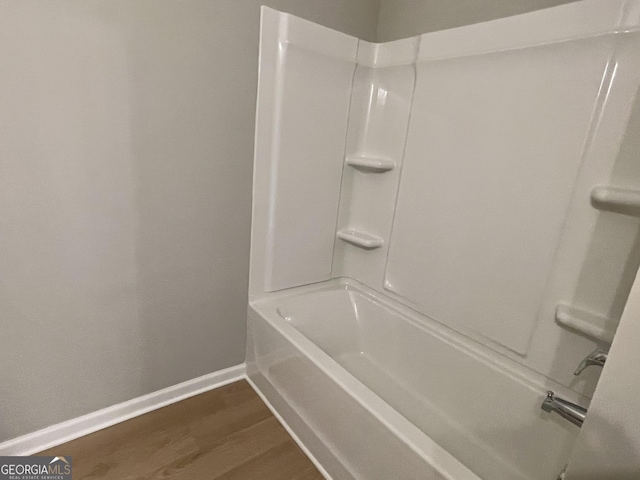 full bathroom with shower / bath combination, baseboards, and wood finished floors