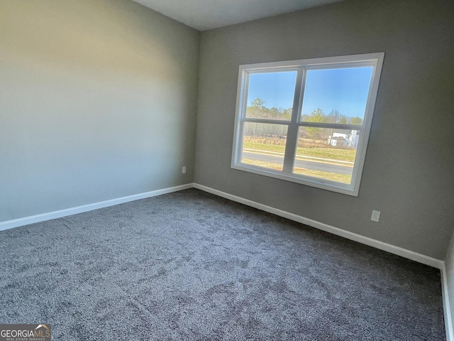 carpeted spare room with baseboards