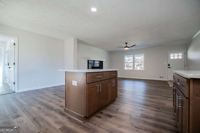 kitchen featuring dark hardwood / wood-style flooring, a center island, and ceiling fan