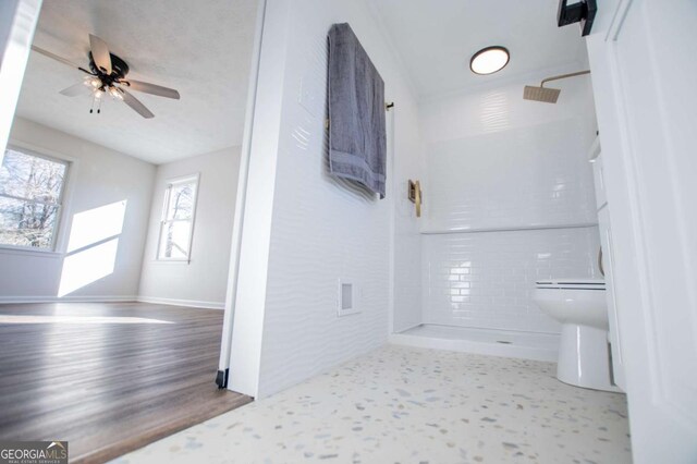 bathroom with a shower, ceiling fan, and toilet