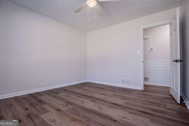 spare room featuring ceiling fan and dark hardwood / wood-style floors