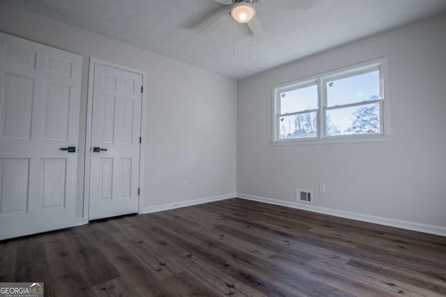 unfurnished bedroom featuring ceiling fan and dark hardwood / wood-style floors