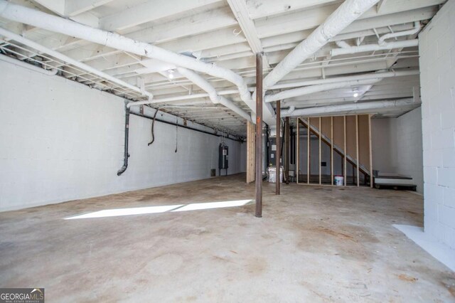 basement featuring electric water heater and heating unit