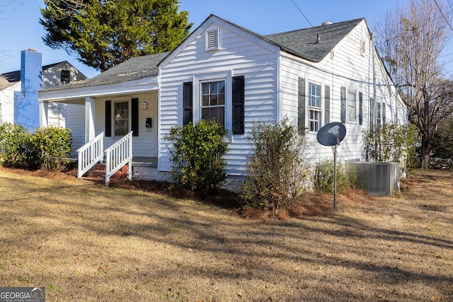 view of front of home featuring a front lawn, covered porch, and central AC unit