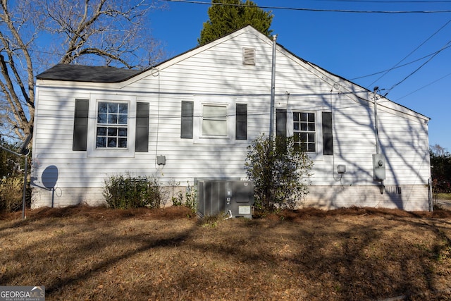 view of side of property with a lawn and cooling unit