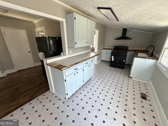 kitchen with crown molding, a sink, wall chimney range hood, and black appliances