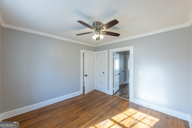 interior space featuring crown molding, ceiling fan, wood finished floors, and baseboards