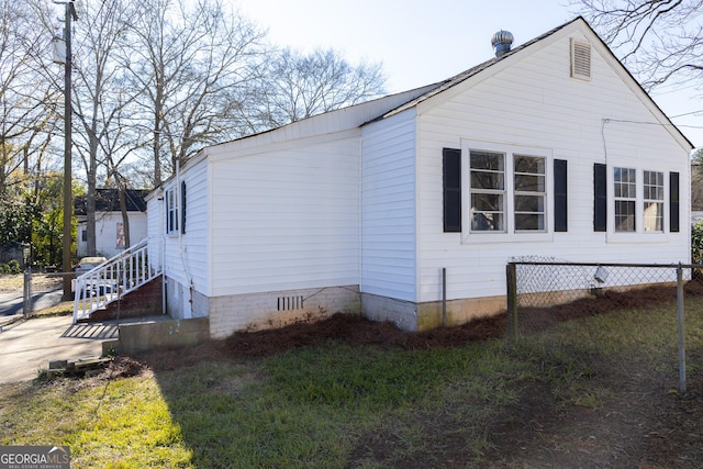 view of side of property with crawl space and fence