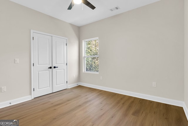 unfurnished bedroom featuring ceiling fan, light wood-type flooring, and a closet