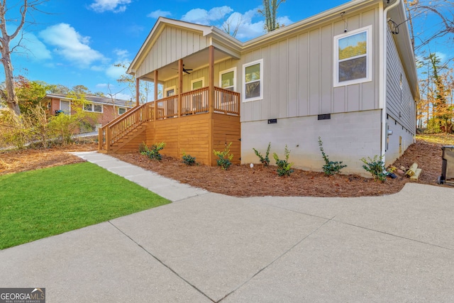 view of front facade with ceiling fan, a porch, and a front yard