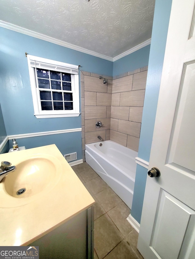 bathroom with sink, ornamental molding, tile patterned floors, a textured ceiling, and tiled shower / bath