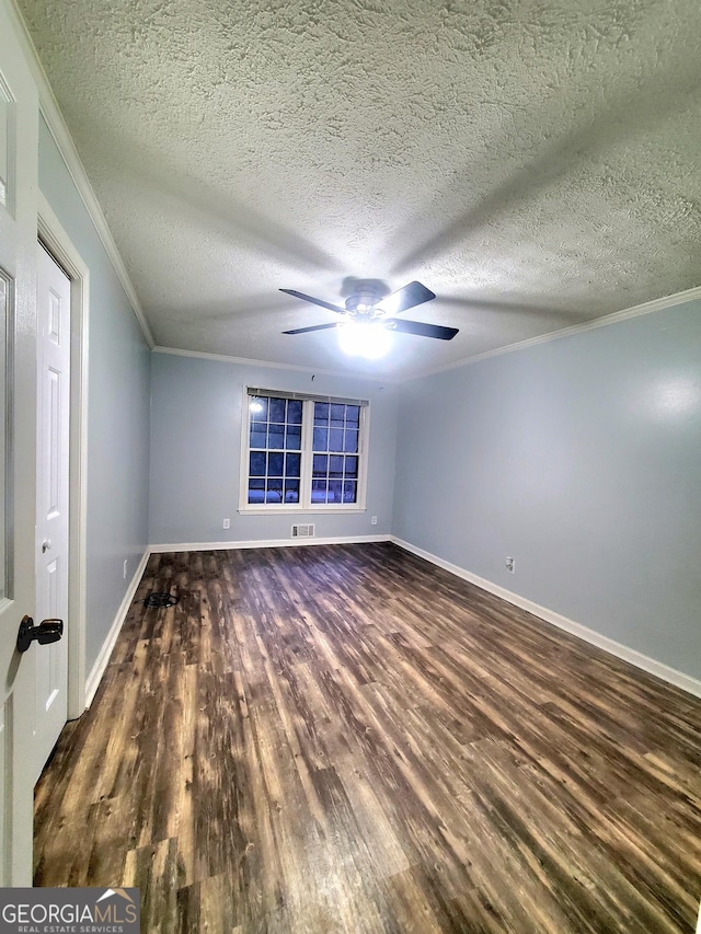 spare room with a textured ceiling, dark hardwood / wood-style floors, and crown molding