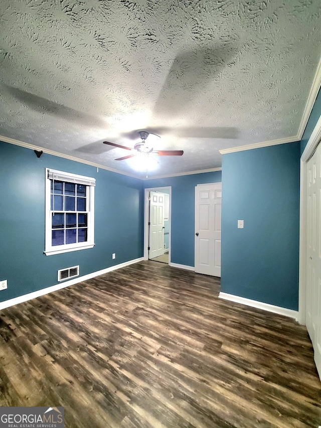 unfurnished bedroom with crown molding, ceiling fan, dark wood-type flooring, and a textured ceiling