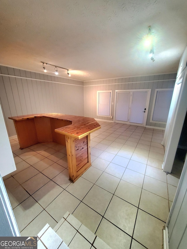 kitchen with light tile patterned floors, a textured ceiling, and rail lighting