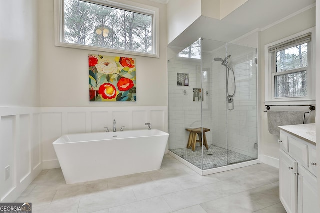 bathroom with independent shower and bath, vanity, tile patterned floors, and a healthy amount of sunlight