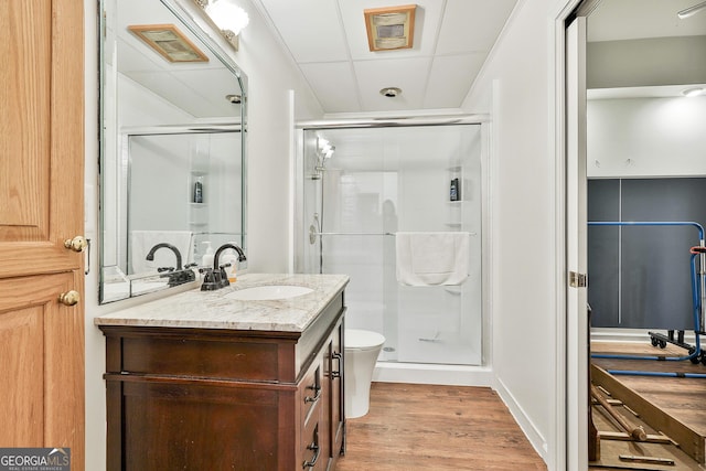 bathroom featuring toilet, a shower with door, vanity, and hardwood / wood-style flooring