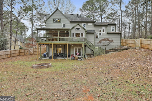 back of property featuring a patio area, a fire pit, and a deck