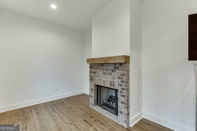 unfurnished living room with wood-type flooring and a fireplace