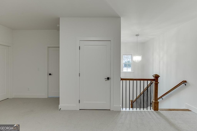 carpeted entryway featuring a notable chandelier