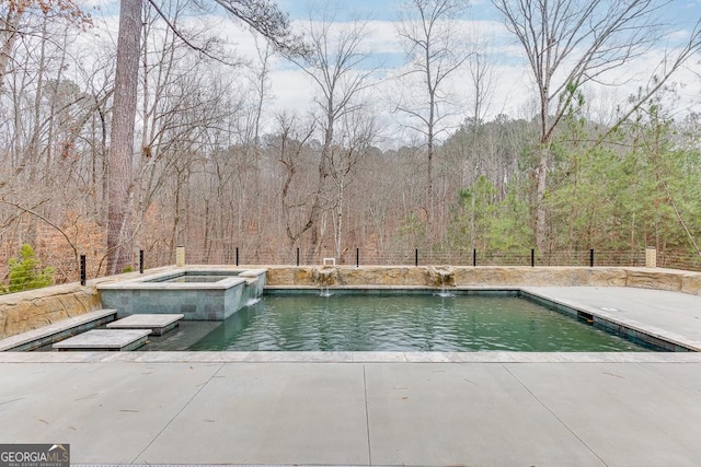 view of pool featuring pool water feature and an in ground hot tub