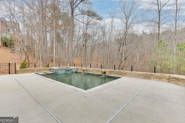 view of pool featuring an in ground hot tub, pool water feature, and a patio area