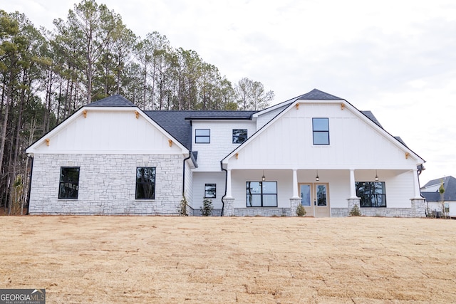 rear view of house with a yard and a porch