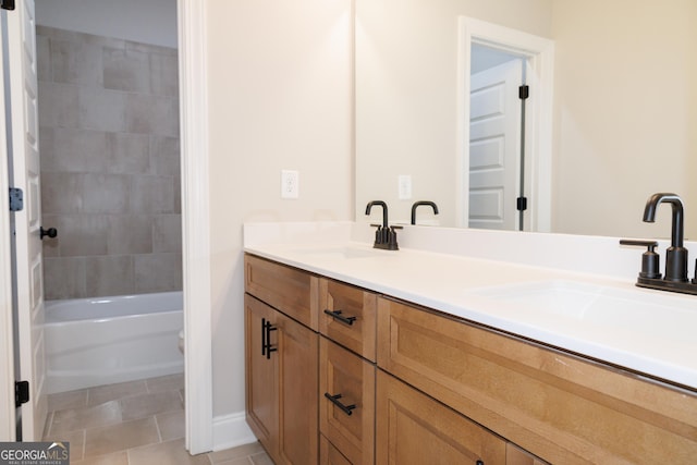 bathroom featuring tiled shower / bath, vanity, and tile patterned flooring