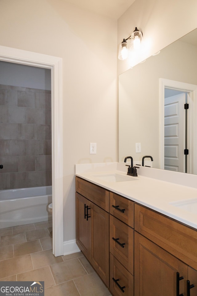 full bathroom featuring vanity, toilet, tiled shower / bath combo, and tile patterned flooring