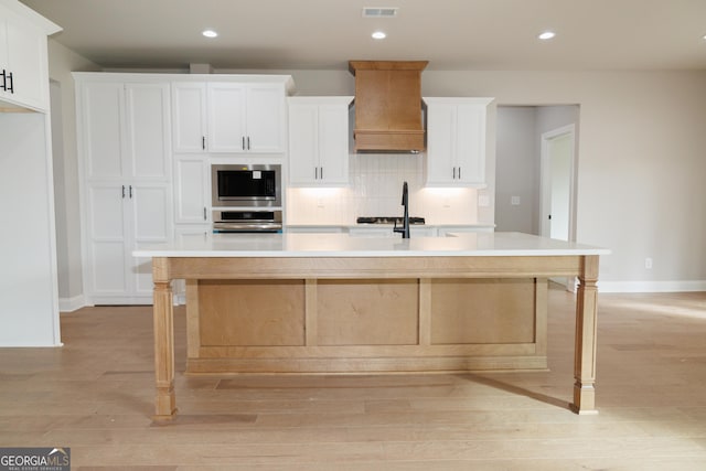 kitchen featuring stainless steel appliances, white cabinetry, and a spacious island