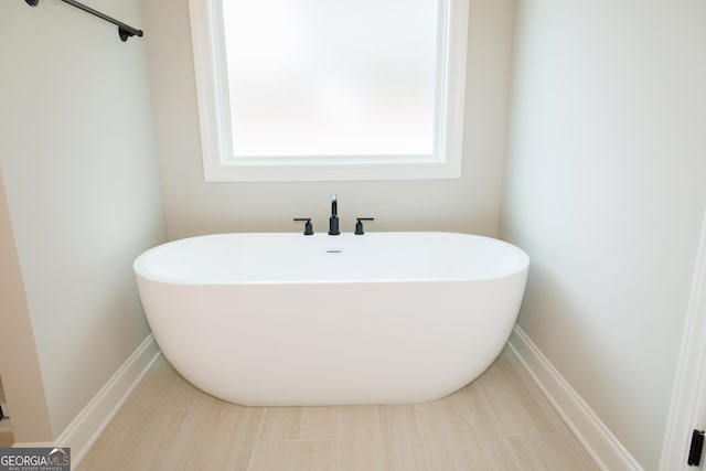 bathroom with a bath and tile patterned floors