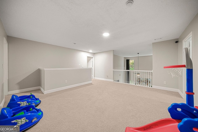 game room with light carpet and a textured ceiling