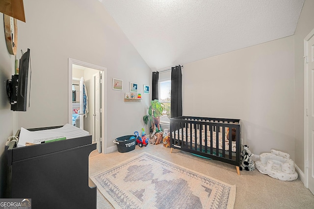 carpeted bedroom with a crib, a textured ceiling, and high vaulted ceiling