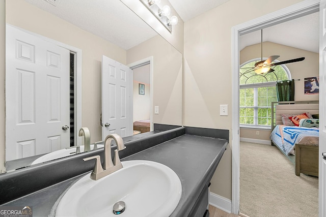 bathroom featuring a textured ceiling, vanity, vaulted ceiling, and ceiling fan